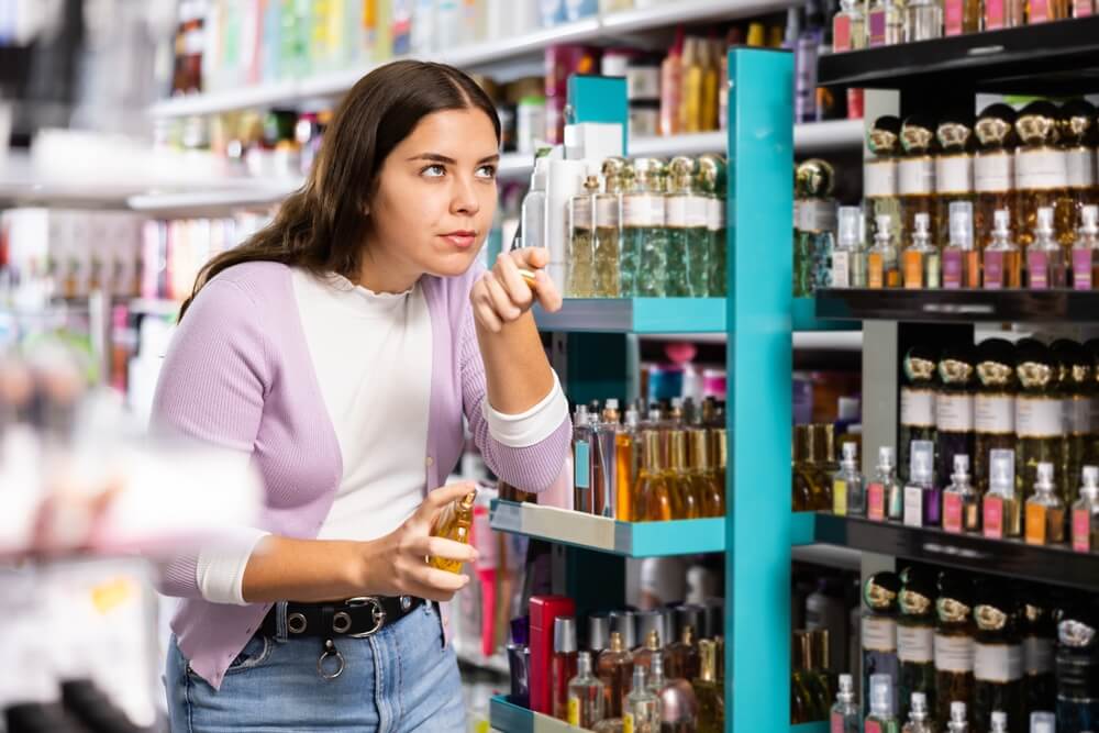 devojka u prodavnici bira najbolji letnji parfem za sebe