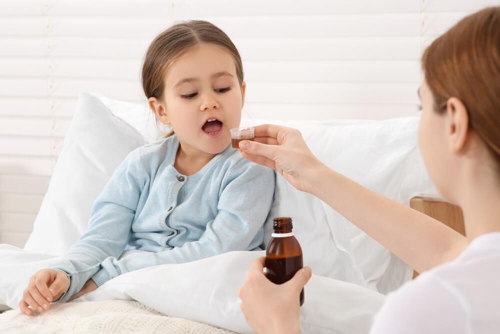 mama daje ćerci sirup za kašalj za decu