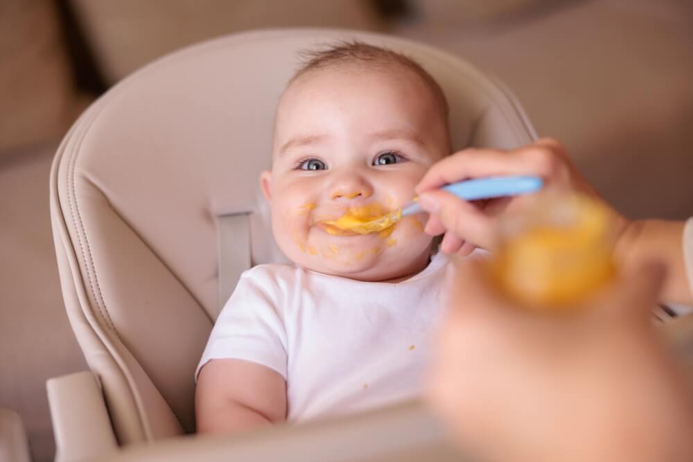 beba uživa dok je mama hrani hranom za bebe