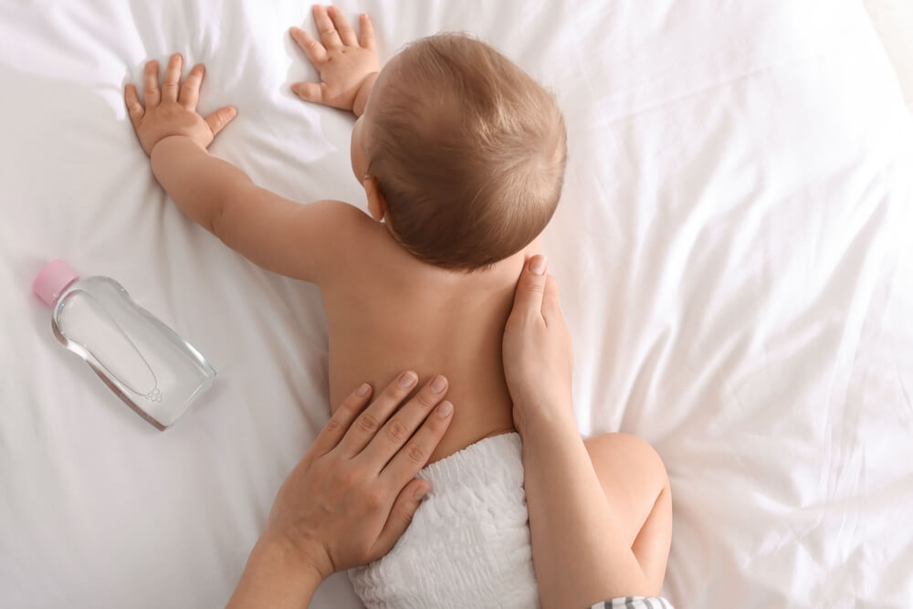 mama masira bebu na krevetu uljem za bebe